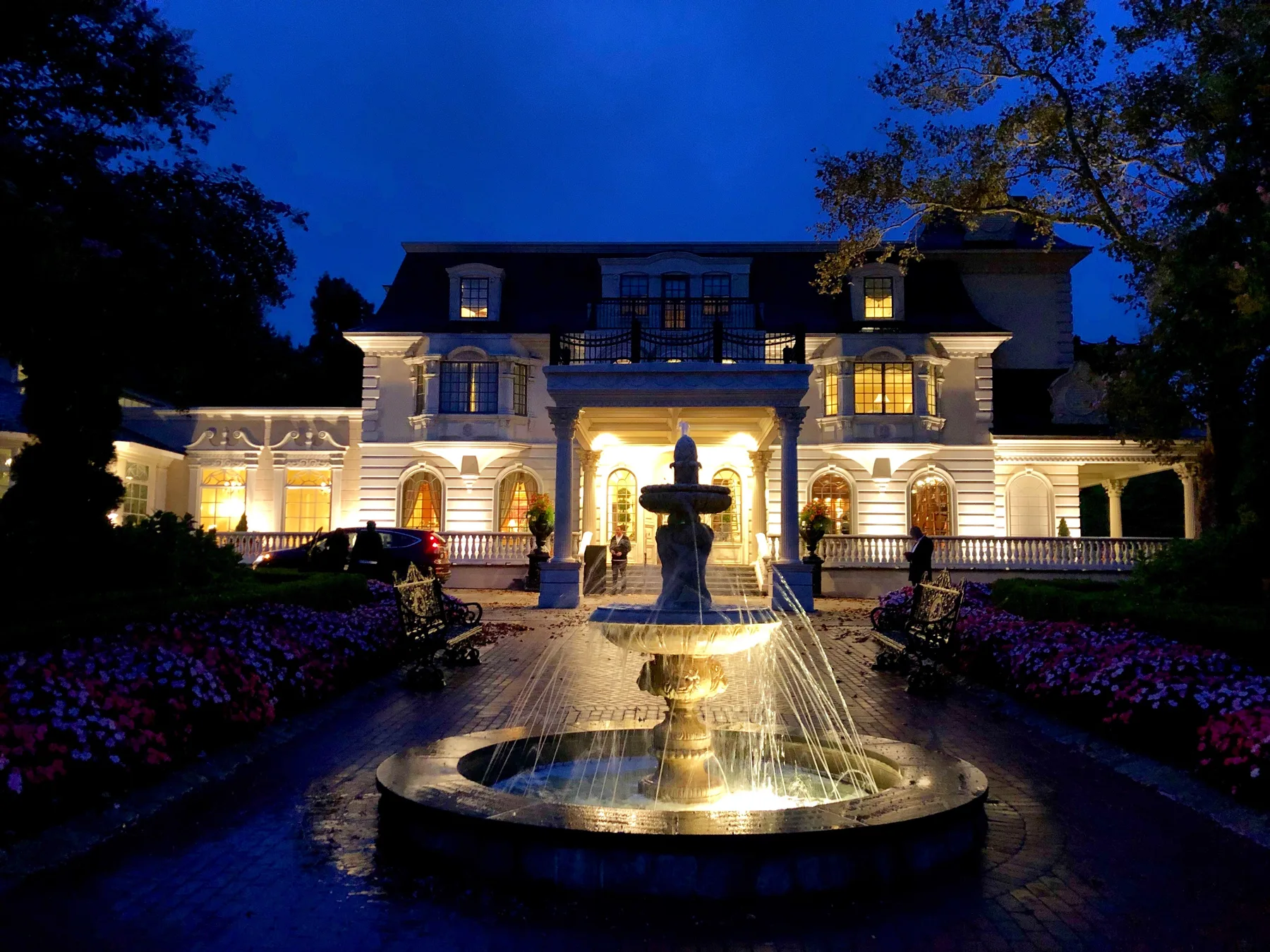 A fountain and warmly lit event venue at dusk